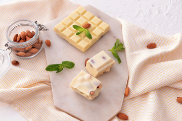 Sweet white chocolate with nuts and mint on table
