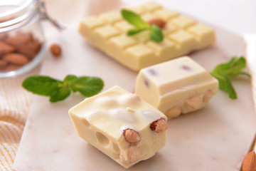 Sweet white chocolate with nuts and mint on table