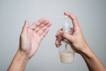 Hand holding a oval shape bottle of hand wash preparing to clean his hand with isolated white background
