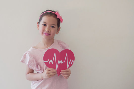Mixed race child holding big red heart with cardiogram,  children health care, life insurance business concept, world heart day, world health day