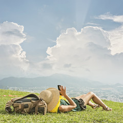 woman lie on grassland and using cellphone