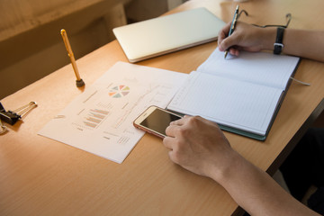 Business people is sitting on the desk, data record and use the notebook computer to search for information.