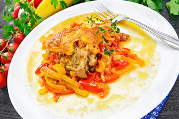 Chicken with pepper in white plate on board