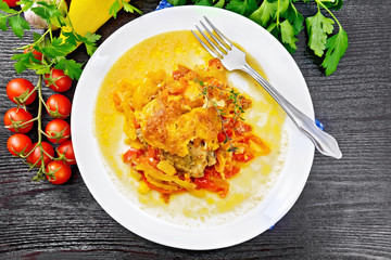 Chicken with pepper in white plate on dark board top