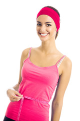 Obraz na płótnie Canvas Woman in red fitness wear measuring waist with a tape measure, isolated over white background