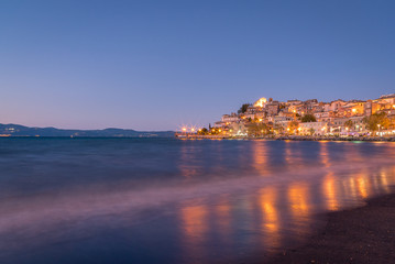 Colourful reflections of lights on the water from the town of Anguillara Sabazia in Italy