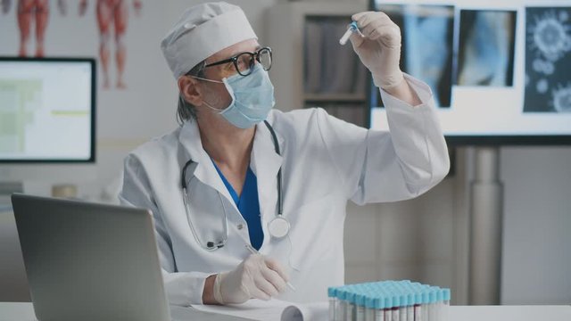Doctor making records of blood sample tests results