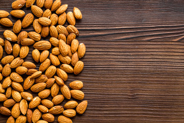 Healthy food. Almond frame on dark wooden table top-down copy space