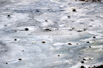 Winter background. The ice and rocks. Top view of the river. Nature draws.