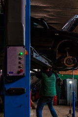 The mechanic lifted the car with a lift to service the engine