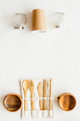 Paper glass, glass jar, wooden tableware on white desk, top view. Eco friendly packaging for take away copy space