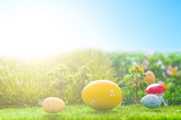 Colorful easter eggs and one big yellow easter egg on spring green grass