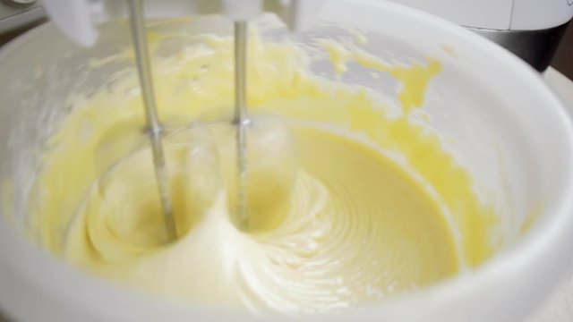 Close-up of a modern mixer whipping cream cake in a home kitchen