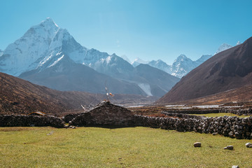  Picturesque view of green grass lawn pasture near the Pheriche village in the Khumbu region of eastern Nepal with majestic Ama Dablam mountain 6812m on background. Remote traveling gems concept image