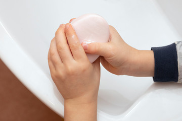 child washes, cleans hands with soap. Hygiene concept
