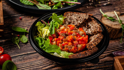 Balanced diet, keto diet. Tartare from vegetables, salad and whole grain rye bread. The concept of sports nutrition in disposable eco dishes.