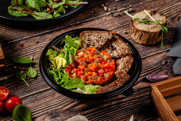 Balanced diet, keto diet. Tartare from vegetables, salad and whole grain rye bread. The concept of sports nutrition in disposable eco dishes.