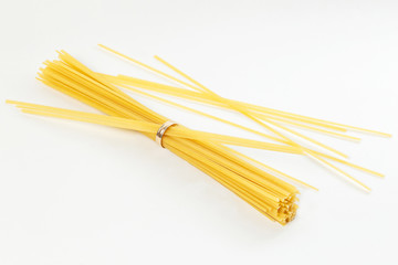 Italian spaghetti on a white background inserted into a golden wedding ring. Serving per person. The perfect measure of serving.