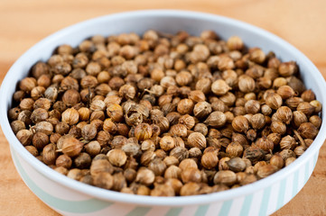 Coriander grains shot large on a wooden background. Background for spices and cuisine.