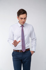 Young, handsome man in a white shirt with a tie on a white background in studio