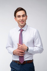 Young, handsome man in a white shirt with a tie on a white background in studio