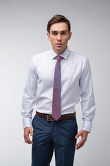 Young, handsome man in a white shirt with a tie on a white background in studio