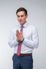 Young, handsome man in a white shirt with a tie on a white background in studio