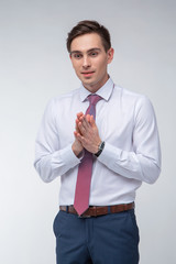 Young, handsome man in a white shirt with a tie on a white background in studio