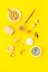Clay mask in bowl for facial spa on yellow background top view