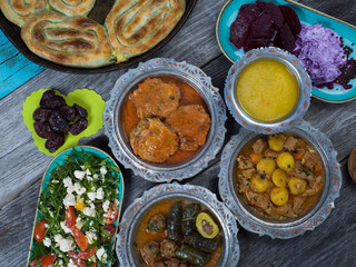 Eid Mubarak Traditional Ramadan Iftar dinner. Assorted tasty food in authentic rustic dishes on wooden table background.