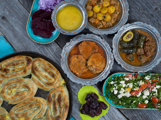 Eid Mubarak Traditional Ramadan Iftar dinner. Assorted tasty food in authentic rustic dishes on wooden table background.