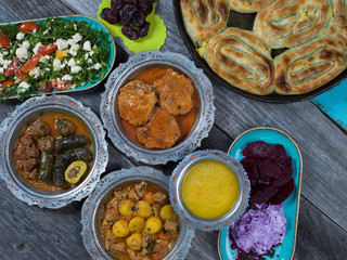 Eid Mubarak Traditional Ramadan Iftar dinner. Assorted tasty food in authentic rustic dishes on wooden table background.