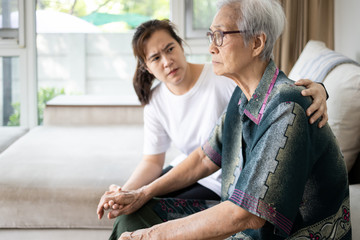 Caregiver woman is taking care,support of sad senior, depressed elderly looking away outside waiting for her family to visit at nursing home, nostalgia, stressed, anxious,life depression of old people