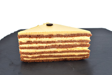 A closeup of a multilayered cake with decorations isolated on white