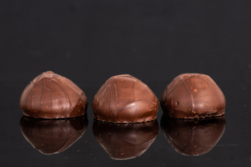 Three chocolate semicircular candies on a dark background