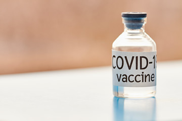 Conceptual image. Vaccine bottle to protect from Covid-19. Closeup, blue background. Healthcare and medical concept.