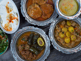 Eid Mubarak Traditional Ramadan Iftar dinner. Assorted tasty food in authentic rustic dishes on wooden table background.