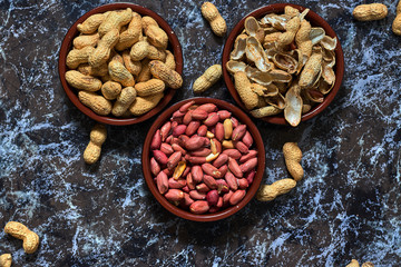 Two bowls with peanuts and one with shells