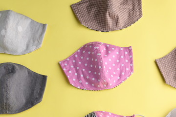 flat lay design of colorful fashion face mask handmade from fabric cloth on yellow background