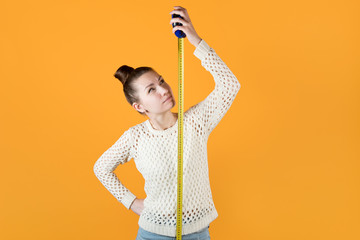 girl looks suspiciously at a measuring tape stretched next to her