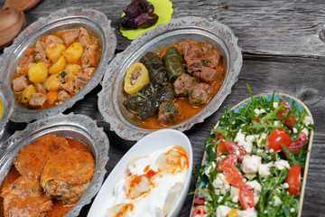 Eid Mubarak Traditional Ramadan Iftar dinner. Assorted tasty food in authentic rustic dishes on wooden table background.