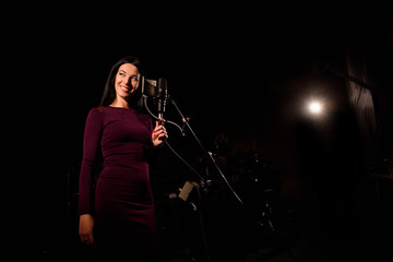 Fototapeta na wymiar Singer recording a song in music studio.