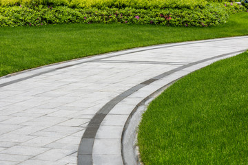 Pathways with green lawns, Landscaping in the garden,Top view of curve walkway on green grass field and flower garden