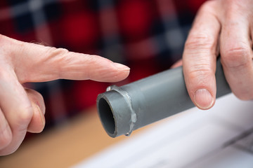 Plumber applying glue on pvc pipe