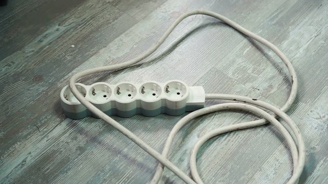 Empty extension cord on floor, top view. Electrician's professional equipment