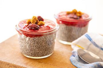 Homemade overnight chia almond pudding with raw raspberry jam and dried fruits