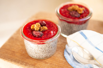 Homemade overnight chia almond pudding with raw raspberry jam and dried fruits