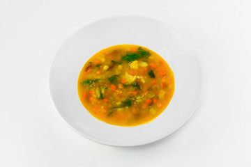 Vegetable soup in a plate on a white background. The view from the top