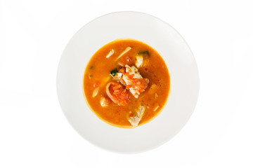 Fish soup in a bowl on white isolated background. Top view, close-up