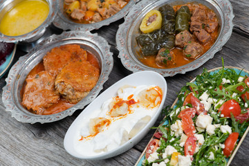Eid Mubarak Traditional Ramadan Iftar dinner. Assorted tasty food in authentic rustic dishes on wooden table background.